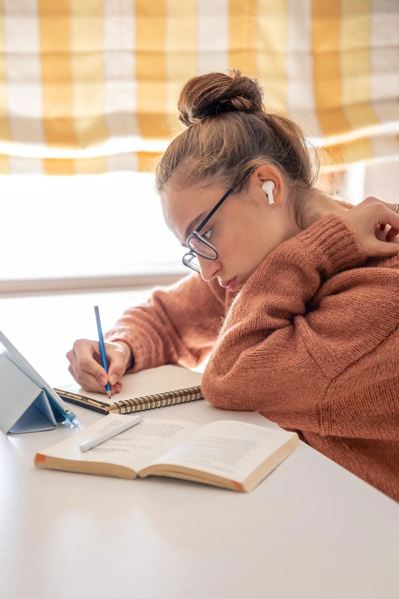 Ein studierendes Mädchen führt zu Hause ein Gespräch am Telefon.